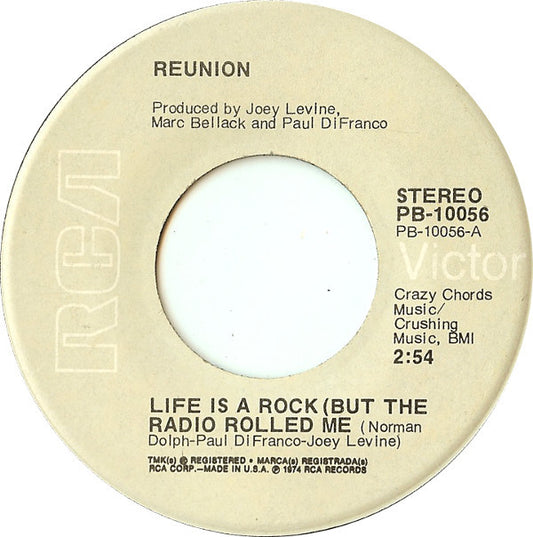 Reunion (3) - Life Is A Rock (But The Radio Rolled Me) (7", Single, Ind)